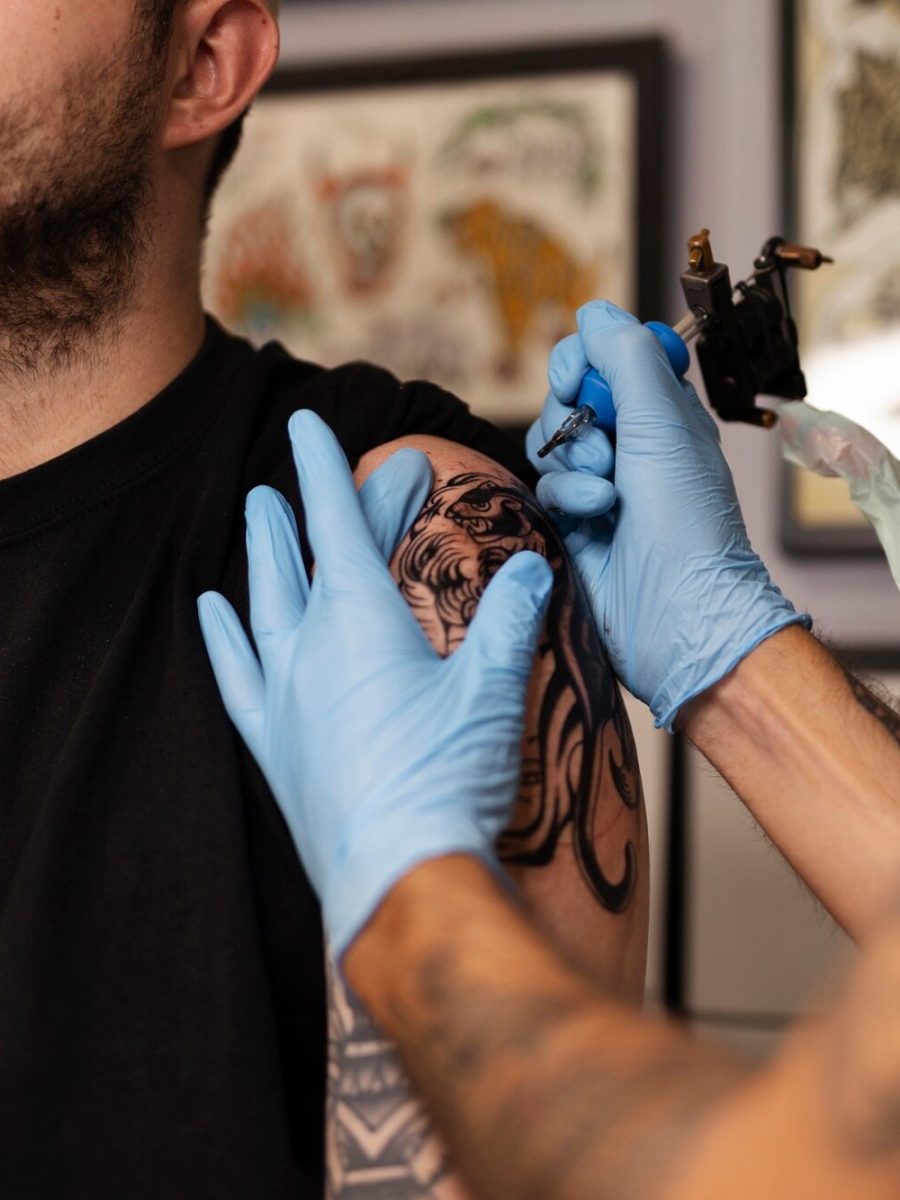 uomo-che-tatua-con-guanti-vista-laterale_23-2149525954